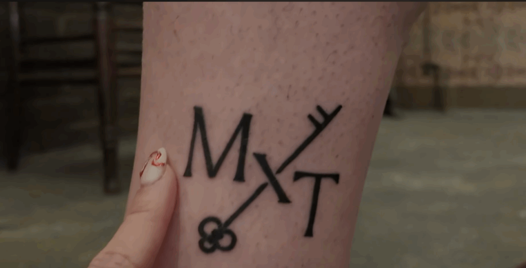 TomieDrone's tattoo of Mx Tomie's logo.